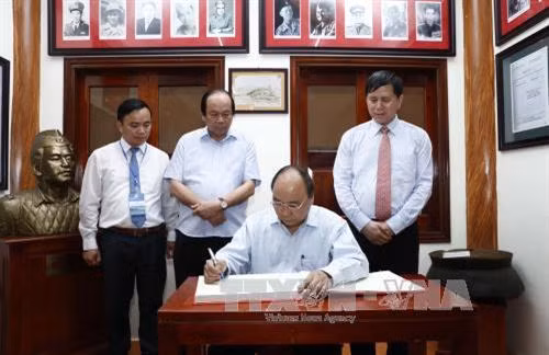 Thủ tướng Nguyễn Xuân Phúc ghi sổ lưu niệm tại Khu di tích lịch sử lưu niệm Trung đoàn 52 Tây Tiến. Ảnh: Doãn Tấn - TTXVN