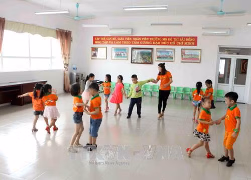 Giáo viên hướng dẫn trẻ mẫu giáo lớp 5 tuổi học khiêu vũ. Ảnh: Quý Trung – TTXVN