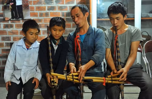 Nghệ nhân Mua Mí Say (thứ hai, bên phải), thôn Tả Lủng B, xã Tả Lủng, huyện Mèo Vạc đang hướng dẫn cách sử dụng khèn cho các thế hệ sau.