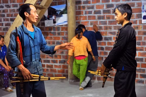 Nghệ nhân Mua Mí Say (bên trái), thôn Tả Lủng B, xã Tả Lủng, huyện Mèo Vạc đang hướng dẫn cách sử dụng khèn cho các thế hệ sau