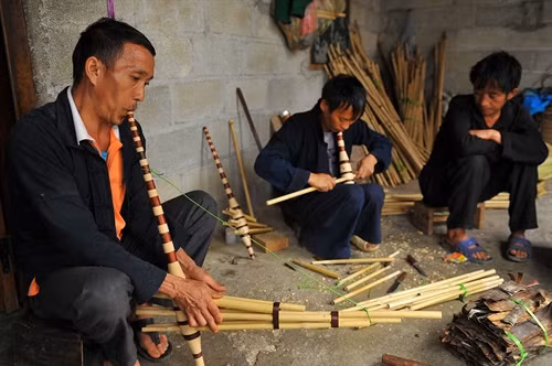 Người mua thử âm thanh của cây khèn vừa mới làm xong