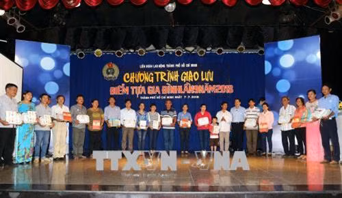 Lãnh đạo Liên đoàn Lao động Thành phố Hồ Chí Minh trao quà và biểu trưng cho các gia đình tiêu biểu vượt khó, xây dựng gia đình hạnh phúc. Ảnh: Thanh Vũ – TTXVN