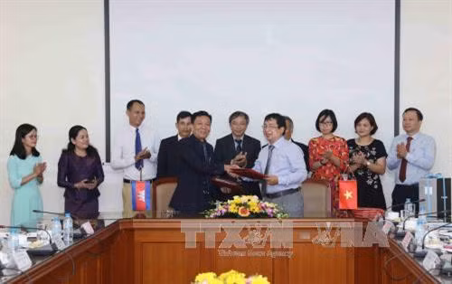 Phó Tổng giám đốc AKP Keo Chandara và Giám đốc Trung tâm Kỹ thuật TTXVN Nguyễn Tuấn Hùng ký kết biên bản bàn giao trang thiết bị kỹ thuật giữa hai bên. Ảnh: Phương Hoa – TTXVN
