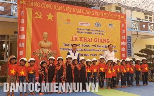 Trao tặng mũ bảo hiểm cho học sinh lớp 1 ở trường Phổ thông Dân tộc bán trú Tiểu học Mù Cả. Ảnh: Hoàng Tâm