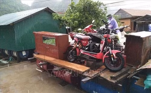 Người dân di chuyển đồ đạc, vật dụng của gia đình lên nhà phao, bè phao để tránh lũ. Ảnh: Võ Dung-TTXVN