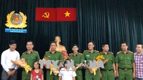 Người dân chung cư Carina tặng hoa tri ân Cảnh sát PCCC Thành phố Hồ Chí Minh. Ảnh: Thành Chung - TTXVN