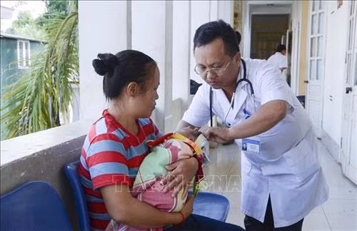 Bác sĩ hướng dẫn bà mẹ chăm sóc giữ ấm cho trẻ sơ sinh. Ảnh: Xuân Tư – TTXVN