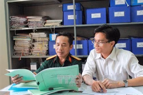 Thượng tá Lê Văn Chung chia sẻ với phóng viên TTXVN về những thông tin, bài báo liên quan đến hài cốt liệt sĩ hy sinh ở Campuchia mà anh lưu giữ trong nhiều năm qua. Ảnh: Xuân Khu - TTXVN