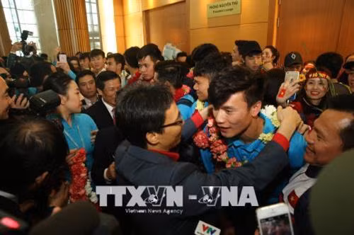 Phó Thủ tướng Chính phủ Vũ Đức Đam tặng hoa chúc mừng thủ môn Bùi Tiến Dũng. Ảnh: TTXVN phát