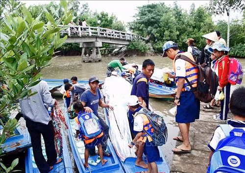 Học sinh ở huyện Ngọc Hiển đến trường bằng đò. Ảnh : Huỳnh Thế Anh – TTXVN