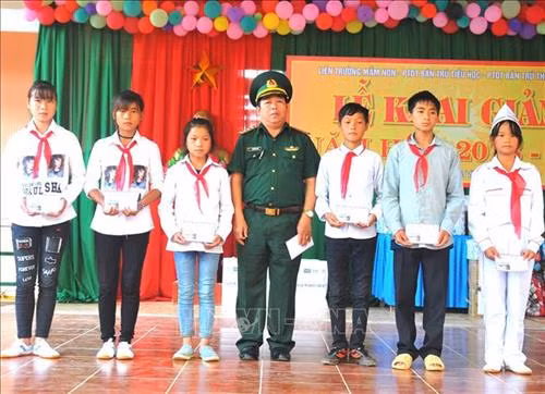 Lãnh đạo Đồn Biên phòng Nghĩa Thuận, huyện Quản Bạ (Hà Giang) trao tặng học bổng “Nâng bước em đến trường” cho các em học sinh Trường Phổ thông Dân tộc bán trú THCS Nghĩa Thuận. Ảnh: Kim Tiến-TTXVN phát
