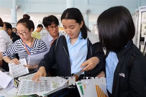 Các em học sinh hào hứng tham quan tại triển lãm Tem bưu chính miền Trung – Tây Nguyên lần thứ V. Ảnh: Hoài Nam - TTXVN
