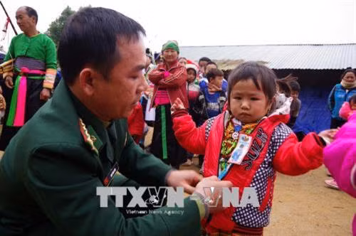 Bộ đội biên phòng tặng áo ấm cho em bé. Ảnh: Duy Hưng-TTXVN