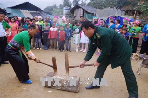 Bộ đội biên phòng cùng tham gia giã bánh giầy với đồng bào Mông ở bản Pù Đứa, xã Quang Chiểu trong dịp Tết. Ảnh: Duy Hưng - TTXVN