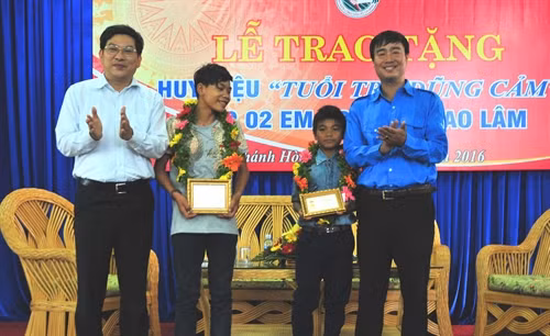 Phó Chủ tịch UBND tỉnh Khánh Hòa Nguyễn Duy Bắc (trái ) trao Huy hiệu “Tuổi trẻ dũng cảm” cho hai thiếu niên cứu 5 học sinh khỏi chết đuối . Ảnh: Nguyên Lý- TTXVN