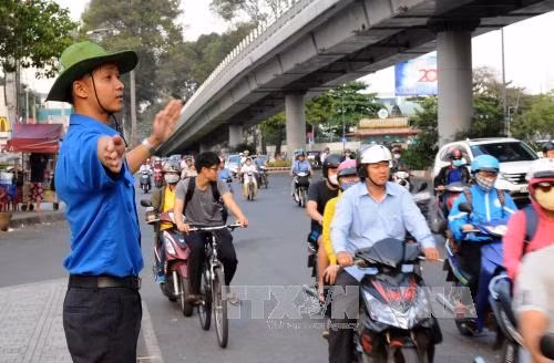 Các thanh niên tình nguyện tham gia điều phối giao thông tại nút giao thông trên đường 3/2, Quận 10, Thành phố Hồ Chí Minh Ảnh: An Hiếu - TTXVN
