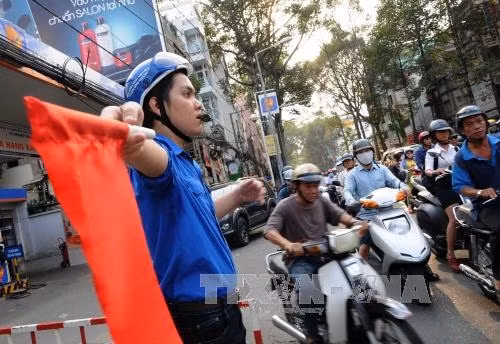 Các thanh niên tình nguyện tham gia điều phối giao thông tại ngã tư Trần Hưng Đạo – Nguyễn Văn Cừ, Quận 5, Thành phố Hồ Chí Minh Ảnh: An Hiếu - TTXVN
