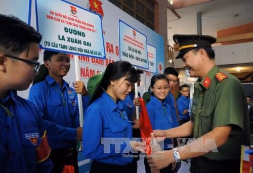 Bí thư Đoàn thanh niên Công an Thành phố Hồ Chí Minh Nguyễn Văn Thanh tặng dụng cụ điều phối giao thông cho các đoàn viên thanh niên tại chương trình Ảnh: An Hiếu – TTXVN