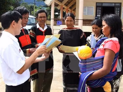Cán bộ Sở Tư pháp hướng dẫn người dân xã Cư Pui, huyện Krông Bông, Đắk Lắk tìm hiểu các văn bản pháp lý. Ảnh: Phạm Cường - TTXVN