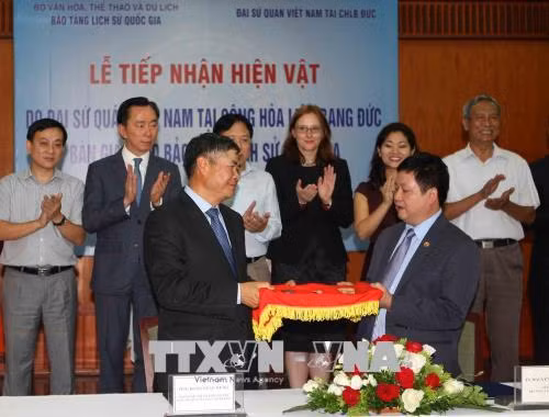 Ông Đoàn Xuân Hưng, Đại sứ đặc mệnh toàn quyền Việt Nam tại Cộng hòa Liên bang Đức bàn giao hiện vật cho ông Nguyễn Văn Cường, Giám đốc Bảo tàng Lịch sử quốc gia. Ảnh: Thanh Tùng-TTXVN