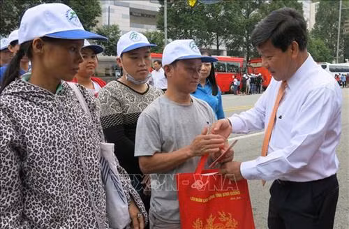 Ông Trần Thanh Liêm, Chủ tịch UBND tỉnh Bình Dương, động viên, tặng quà các công nhân về quê ăn Tết. Ảnh: Hải Âu-TTXVN