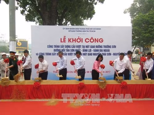 Đồng chí Đinh La Thăng, Ủy viên Bộ Chính trị, Bí thư Thành ủy Thành phố Hồ Chí Minh và các đại biểu thực hiện nghi thức động thổ khởi công xây dựng công trình cầu vượt. Ảnh: Hoàng Hải - TTXVN