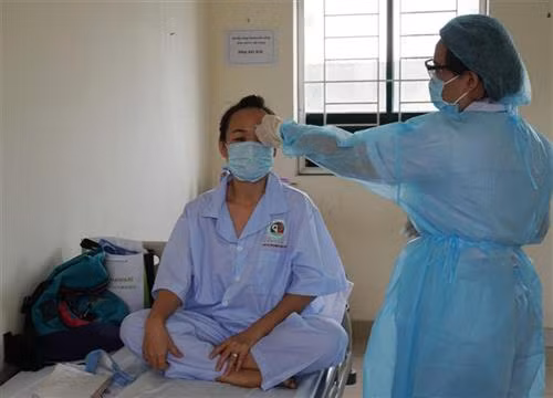 Nhân viên y tế theo dõi tình hình sức khỏe người cách ly tại khu cách ly. Ảnh: Đinh Hằng – TTXVN