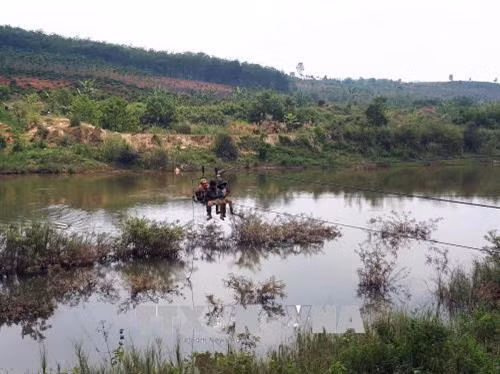 Người dân tại huyện Ngọc Hồi vượt sông bằng đu dây. Ảnh: Quang Thái - TTXVN