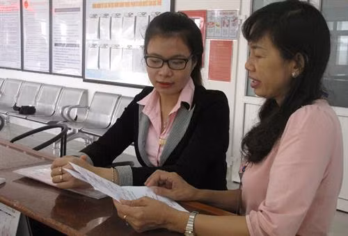 Cán bộ Cục Thuế tỉnh Long An hướng dẫn chính sách thuế cho người nộp thuế. Ảnh: Báo Long An online