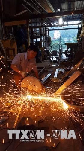 Anh Vũ Văn Quý sáng chế hệ thống thang nâng bằng thủy lực có chốt tự động, bảo đảm an toàn lao động. Ảnh: Diệp Anh – TTXVN
