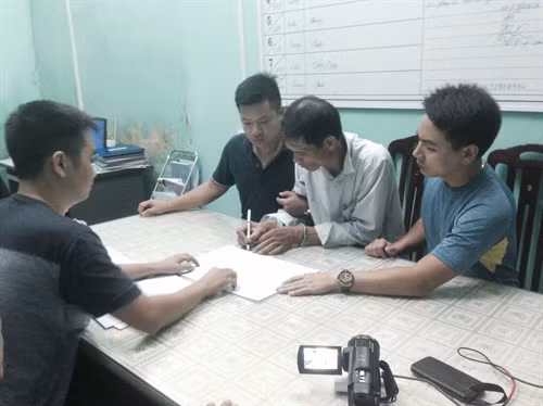 Các điều tra viên lấy lời khai của đối tượng Doãn Trung Dũng (giữa) Ảnh: Nguyễn Hoàng- TTXVN