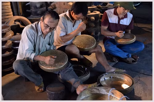 Nghệ nhân Dương Quốc Thuần cùng 2 người con chỉnh âm cho bộ chiêng mới hoàn thành.
