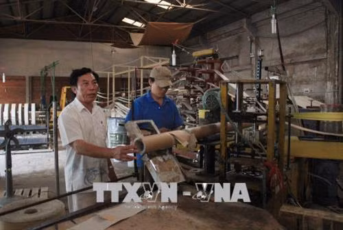 Ông Huỳnh Văn Duyên (trái) luôn quan tâm đến công nhân, những người phần lớn là các cựu chiến binh. Ảnh: Xuân Khu – TTXVN