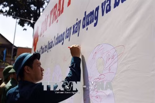 Thanh niên trúng tuyển nghĩa vụ quân sự ký cam kết chung tay xây dựng và bảo vệ Tổ quốc tại hội trại tòng quân. Ảnh: Thanh Vũ -TTXVN