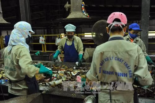 Công nhân Nhà máy xử lý chất thải rắn phân loại rác hữu cơ để sản xuất phân vi sinh. Ảnh: Minh Đức - TTXVN