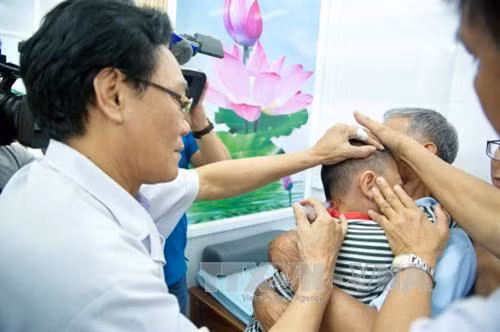 Bác sĩ Bệnh viện Châm cứu Trung ương chuyên bác sĩ Viện Y dược học dân tộc Thành phố Hồ Chí Minh kỹ thuật thủy châm cho trẻ bệnh tự kỷ và thiểu năng não. Ảnh: Phương Vy-TTXVN