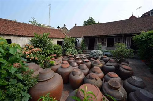 Những chiếc chum đựng tương trong sân nhà cổ của gia đình anh Hà Văn Huyến.