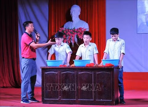Cán bộ Trung tâm Thanh thiếu nhi tỉnh hướng dẫn kỹ năng lấy hơi và nhịn thở cho các em học sinh.Ảnh: Minh Đức - TTXVN