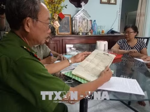 Cảnh sát khu vực hướng dẫn người dân kê khai thông tin cá nhân. Ảnh: Thành Chung - TTXVN