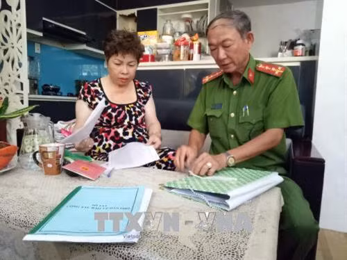 Cảnh sát khu vực hướng dẫn người dân kê khai thông tin cá nhân. Ảnh: Thành Chung – TTXVN