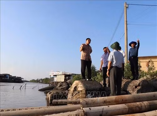 Bộ trưởng Bộ Nông nghiệp và Phát triển nông thôn Nguyễn Xuân Cường kiểm tra tình hình sạt lở bờ sông tại thị trấn Năm Căn, huyện Năm Căn. Ảnh: Huỳnh Thế Anh - TTXVN
