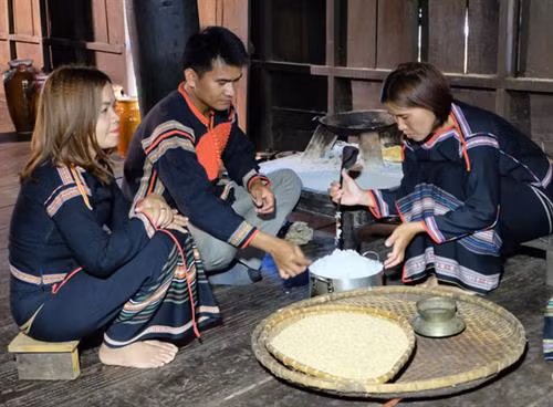 Chị H’Phiu Kbuôr (bên phải) thực hiện công đoạn cơm trộn men để ủ rượu cần.