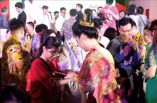 Buộc chỉ cổ tay, chúc nhau năm mới an khang, thịnh vượng, sức khỏe và may mắn. Ảnh: Tường Vi - TTXVN