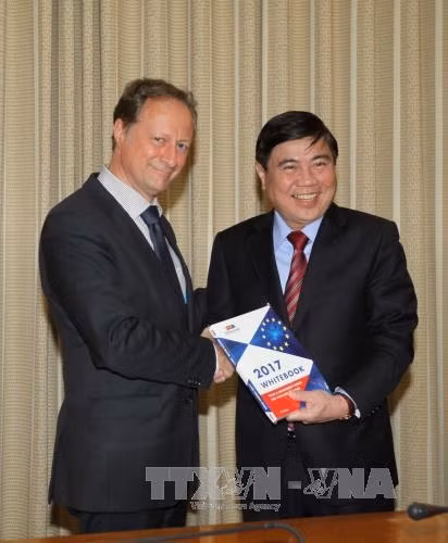 Đại sứ Bruno Angelet tặng sách trắng cho Chủ tịch UBND Thành phố Hồ Chí Minh Nguyễn Thành Phong. Ảnh: Thanh Vũ-TTXVN
