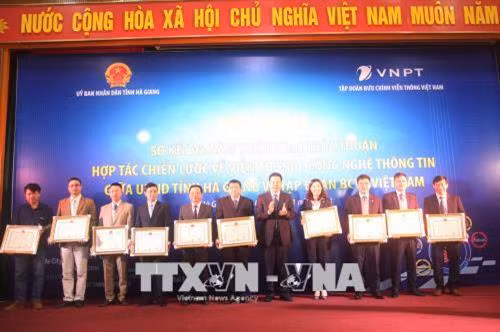Chủ tịch UBND tỉnh Hà Giang Nguyễn Văn Sơn trao tặng Bằng khen cho 3 tập thể, 10 cá nhân có thành tích xuất sắc trong triển khai đẩy mạnh ứng dụng công nghệ thông tin giai đoạn 2014-2017. Ảnh: Minh Tâm-TTXVN