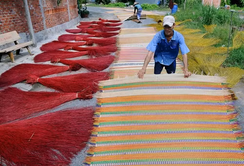 Phơi chiếu và nguyên liệu dệt tại làng nghề chiếu Định Yên.