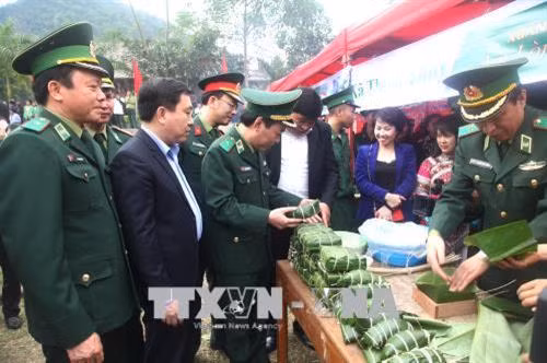 Cán bộ chiến sỹ Bộ đội Biên phòng Hà Giang gói bánh trưng cùng bà con dân tộc thiểu số. Ảnh: Minh Tâm-TTXVN