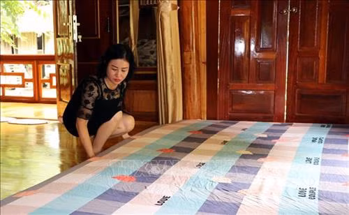 : Chị Đặng Vân Anh – Chủ nhà nghỉ Homestay A Phủ, thôn Nà Tông, xã Thượng Lâm chuẩn bị phòng nghỉ cho khách du lịch. Ảnh Quang Đán – TTXVN