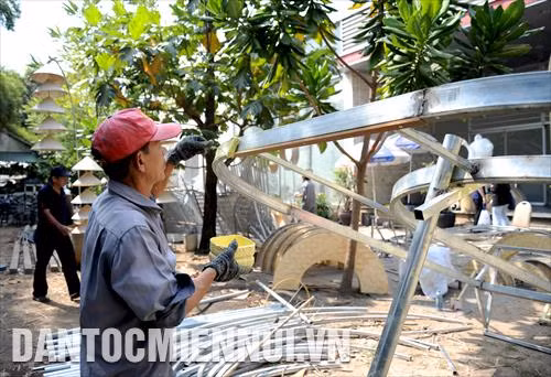 Các công nhân tất bật thực hiện một công đoạn thiết kế các tiểu cảnh của Đường hoa Nguyễn Huệ Tết Canh Tý 2020