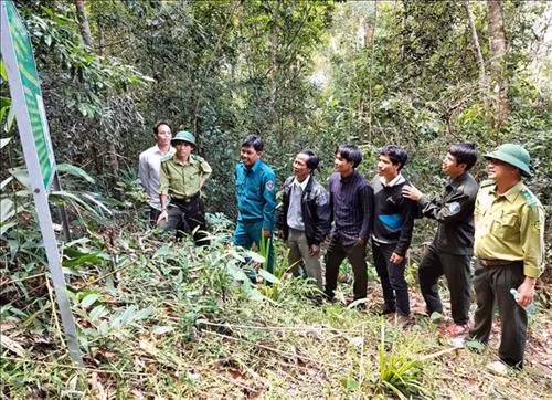 Cán bộ kiểm lâm và bà con nhận khoán bảo vệ rừng tại khu vực rừng của làng Đê KJiêng, xã Ayun, huyện Mang Yang, tỉnh Gia Lai. Ảnh: Dư Toán - TTXVN